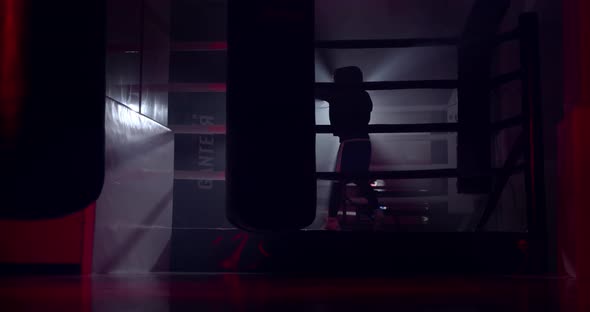 A boxer boxing with a shadow draws quick punches in a semi-dark ring with a backlight alt