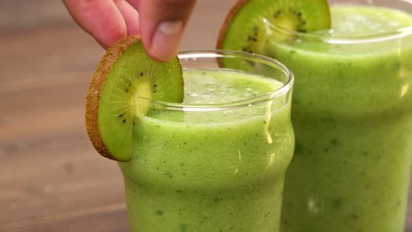 Healthy homemade green smoothies in the glasses being garnished with peppermint