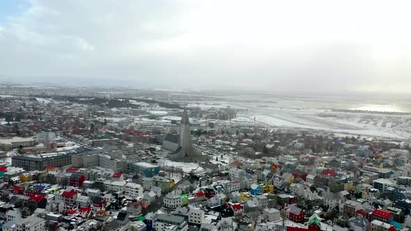 Aerial Panorama Of Reykjavík Cityscape Against Overcast Sky In Iceland. alt