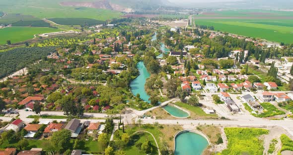 Aerial view of the town with hills in the background and Kibbutzim Stream. alt