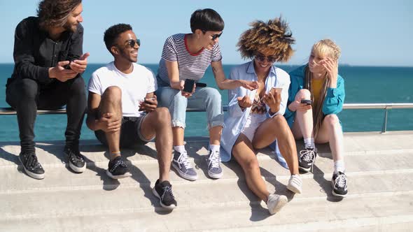 Contemporary Diverse Friends with Smartphones on Seafront alt
