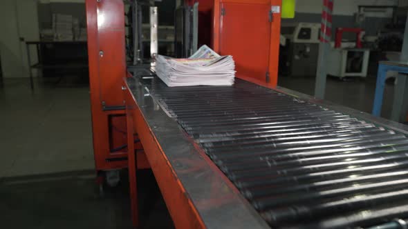 Newspapers Fall Into Large Pile and Move Along the Conveyor Line alt