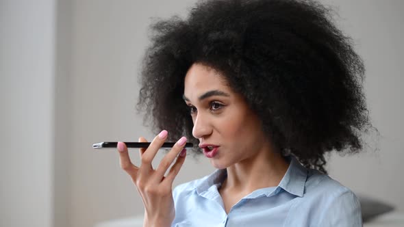 A Young Biracial Woman is Recording Voice Message on a Smartphone