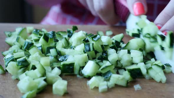 Small Slices of Juicy Green and Ripe Cucumber on Wooden Kitchen Board