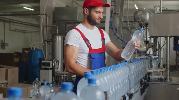 Young Man Worker of Water Factory Checking Quality and Making Inspection in Line Production