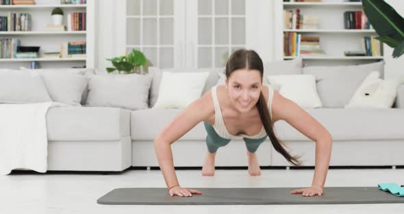 Athletic Brunette Woman is Doing Pushups for Her Biceps