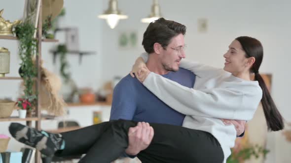 Slow Motion of Man Moving in Circle While Holding Woman in Arms alt