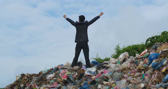 Businessman Celebrating On Garbage Pile alt