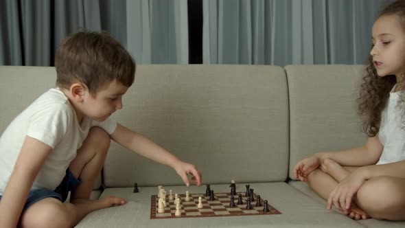 Children Play Chess While Sitting on the Devan at Home the Development of Logical Thinking in alt