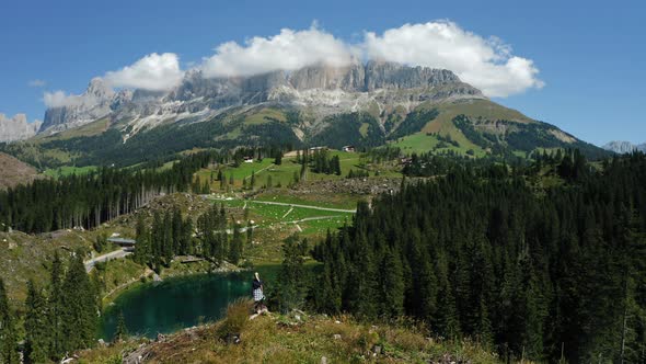 Women on Top of Hill with Uprooted Pine Trees After Strong Wind in Lake Carezza Most Beautiful Lakes alt