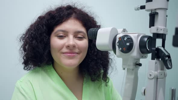 Portrait of Confident Positive Woman Sitting at Retina Camera in Ophthalmologic Clinic Smiling alt