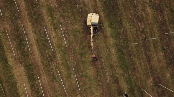 Excavator Drives Concrete Poles Into the Ground alt