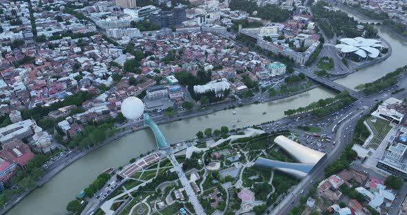 Aerial view of Tbilisi city central park and Bridge of Peace. Beautiful cityscape of old Tbilisi at alt