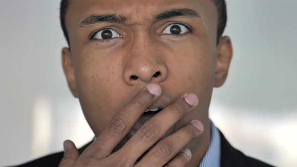 Close Up of Shocked Face of Casual AfroAmerican Businessman Astonished By Loss alt
