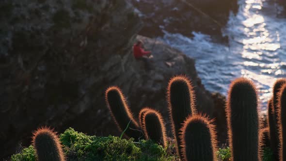  change of focus, man fishing with beautiful sunset light in the middle of the cliff, pichilemu, alt