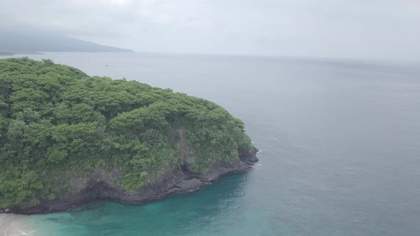 Aerial footage of green cliff, crystal blue sea, foaming waves, Virgin beach, Bali, Indonesia.