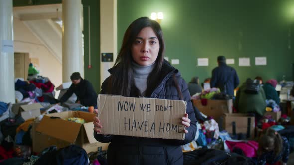 A Portrait of a Sad Armenian Woman in the Large Hall of the Refugee Assistance Center Among a Large