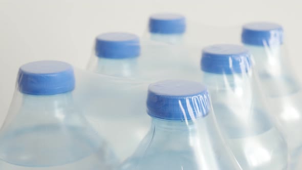 Bottled water package close-up 4K 2160p 30fps UltraHD tilting footage - Row of transparent PET conta alt