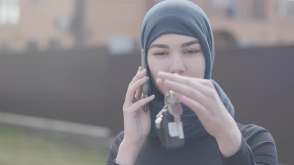 Portrait of Independent Smiling Young Muslim Woman Talking Bey Phone and Holding Car Keys Wearing alt