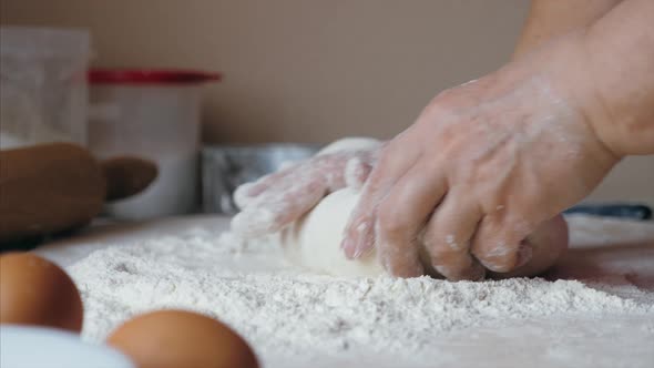 Close-up Hands of Senior Female Is Kneading a Dough at Home Kitchen, Side View