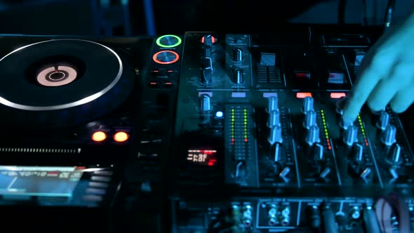 Tracking Shot of a Man DJ Playing with Mixer and Digital Turntables
