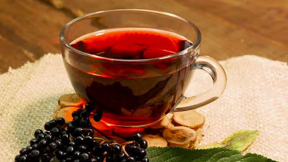 Natural Red Berry Tea In A Glass Cup On A Turntable. Berry Tea From Black Elderberry. Homeopathy