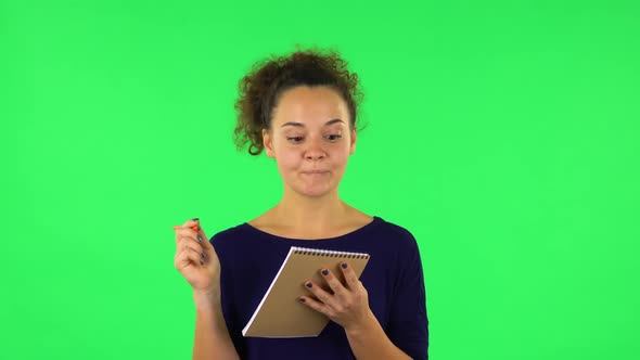 Portrait of Curly Woman with TV Remote in Her Hand, Switching on TV. Green Screen alt
