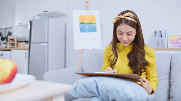 Asian young talented woman artist drawing picture on painting board. alt