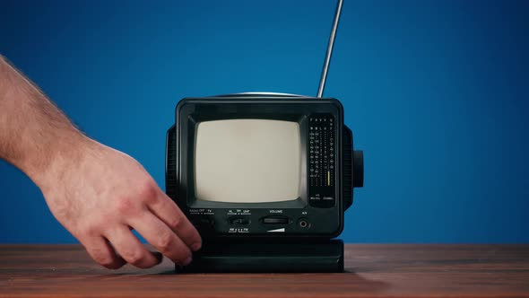Small Old Television with Grey Interference Screen on Blue Background alt