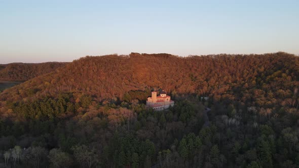 aerial panorama of mountains and forest in autumn with setting sun glowing off the trees.