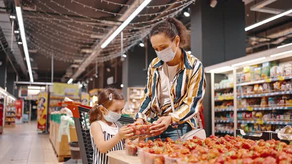 Masked Mom and Daughter Buy Fresh Strawberries at the Hypermarket alt