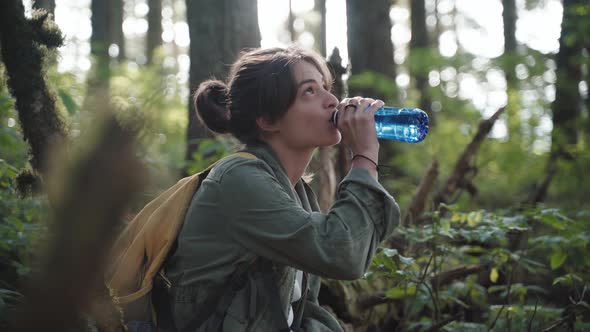 Ethnic Female Drinking Water In Forest