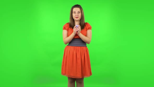 Cute Girl Is Opening a Small Box with a Surprise and Is Very Disappointed with What She Saw. Green alt