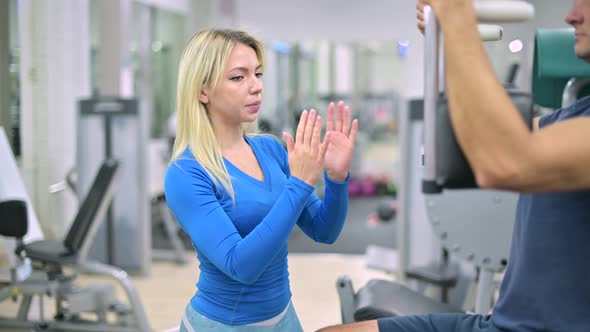gym trainer controls his client's technique alt