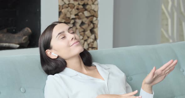 Young Woman Relaxing on Comfortable Couch Enjoying Listening to Lounge Music Live Via Smartphone App alt