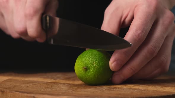 Sliced in half fresh lime with knife on wooden chopping board. Close up. HD