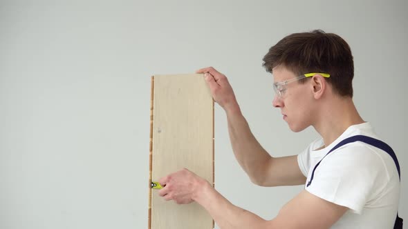The Floor Installer Holds a Parquet or Vinyl Board and Installs the Flooring alt