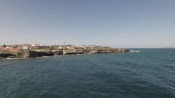 Atlantic ocean waves crashing on cliff, Peniche, Portugal. Aerial sideways shot