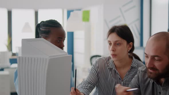 Close Up of People Working with Building Model to Analyze Maquette for Construction Plan alt