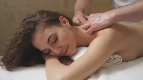 Beautiful Curly Woman Receiving Full Body Massage at Modern Spa