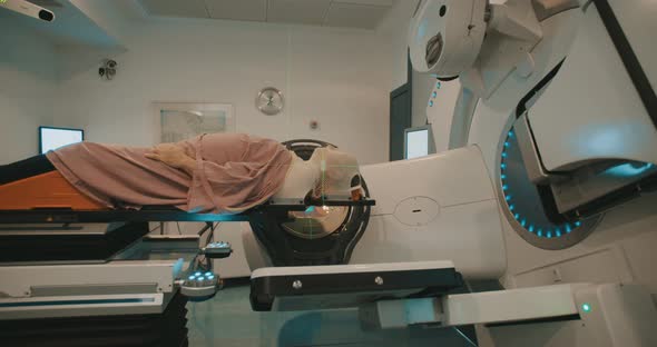 Patient getting Radiation Therapy Treatment inside a large radiotherapy room alt