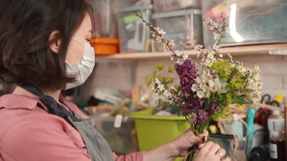 Female Florist Preparing Bouquet and Wear Mask To Prevent Flu Virus. Woman Working During Pandemic