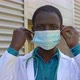 young black doctor wears the mask staring at camera - protection, virus - VideoHive Item for Sale