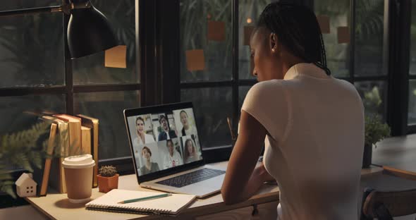 African American woman talking with colleagues online via video calling