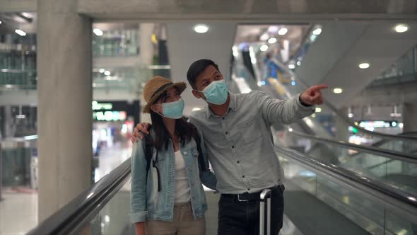 Couple Asian people walking in airport terminal waiting for  flight boarding.