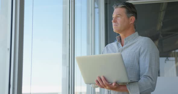 Caucasian male business executive working on laptop in modern office 4k alt