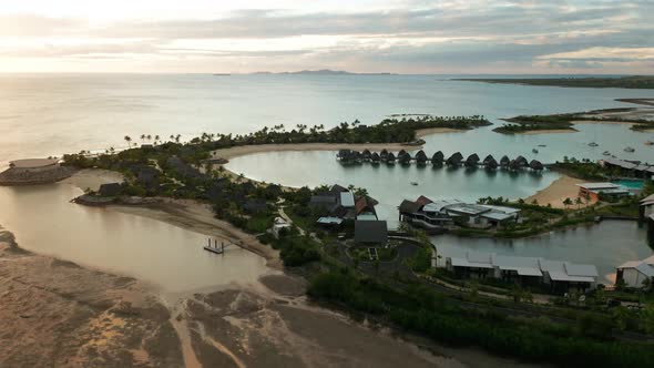 Luxury resort in Pacific Ocean with overwater bungalows in tropical lagoon drone alt