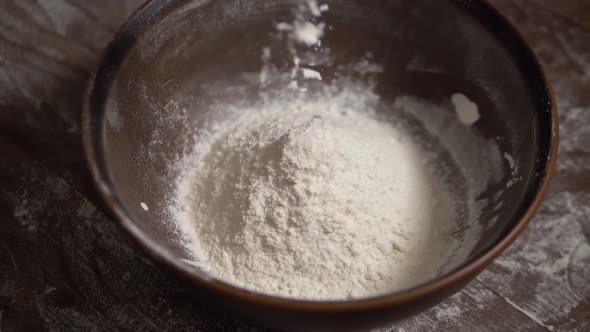 Flour Falls Into a Deep Brown Bowl Slow Motion