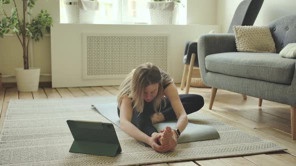 Female Flexible Fitness Training Woman in Sitting Legs Apart Position Stretches