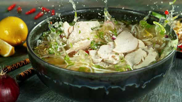 Super Slow Motion Shot of Chicken Slices Falling Into Pho Soup at 1000 Fps. alt
